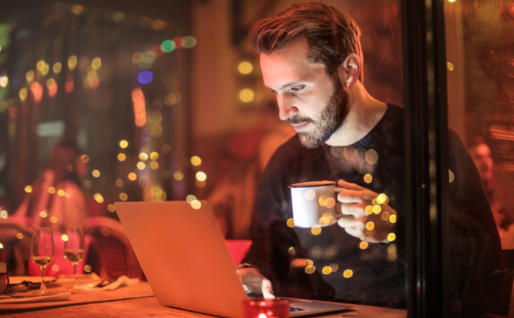 A man looking to his computer, that symbolizes online therapy in English, in Barcelona city.
